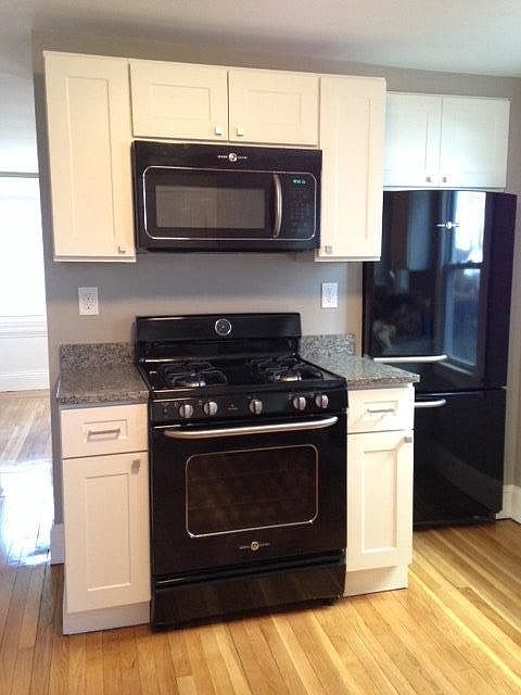 Kitchen w/ GE Artistry appliance suite, white Shaker cabinets