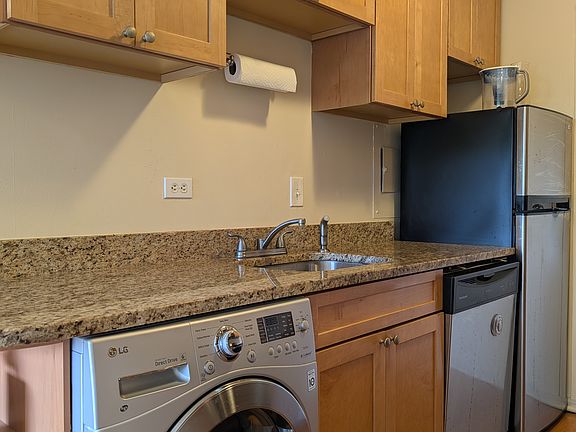 Updated kitchen with granite countertops, stainless steel appliances, and a washer/dryer unit