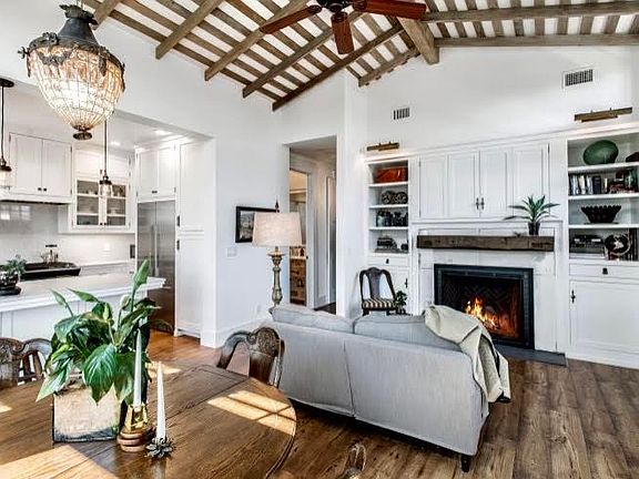 Living room includes a fire place and TV behind the cabinet doors.