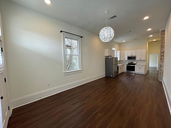 Very large living room that can accommodate sofa area, workspace, and dining area.