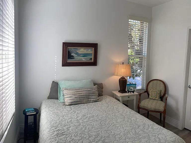 Small black stool to left of bed is convenient for a book, cell phone, or a drink!