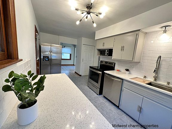 Modern kitchen with quartz countertops and updated stainless steel appliances and pantry area