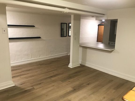 View from living room of kitchen counter and hallway leading to bathroom and bedroom.