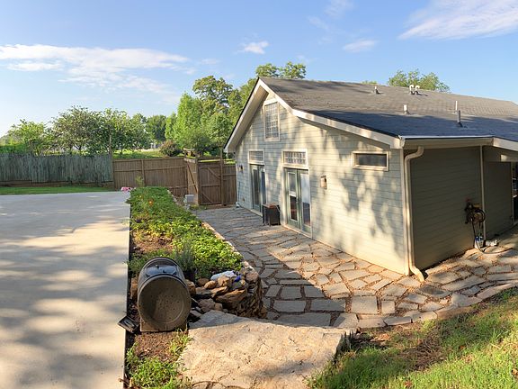 Backyard pano of yard, with shed basketball court, garden and outdoor porch area