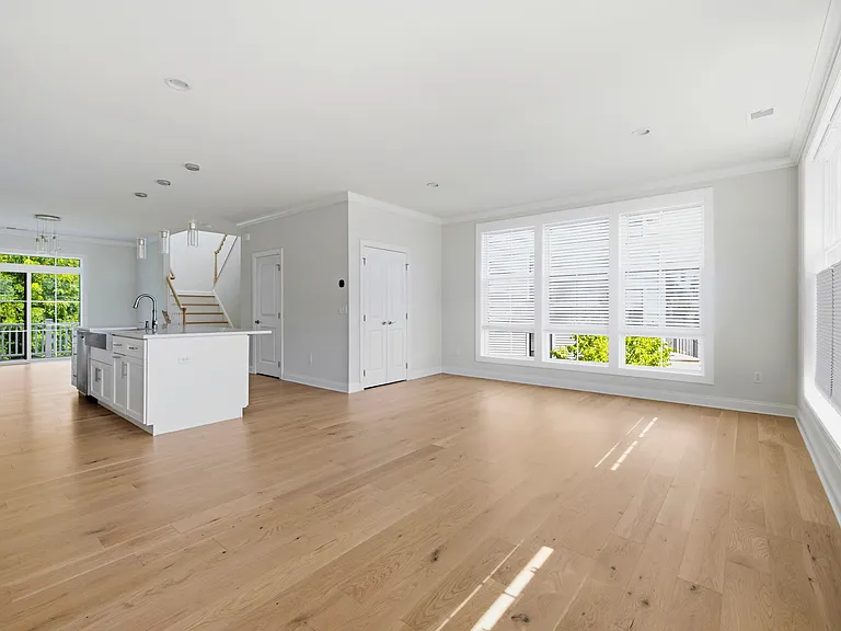 Airy, spacious living room features gorgeous natural light, custom built-in cabinetry, and storage space.