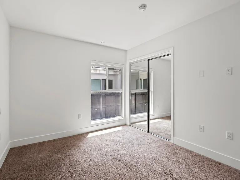 Bedroom with Mirrored Closet and Window