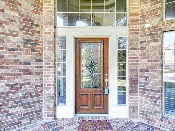 Close up view of the bricked front porch and leaded glass front door.