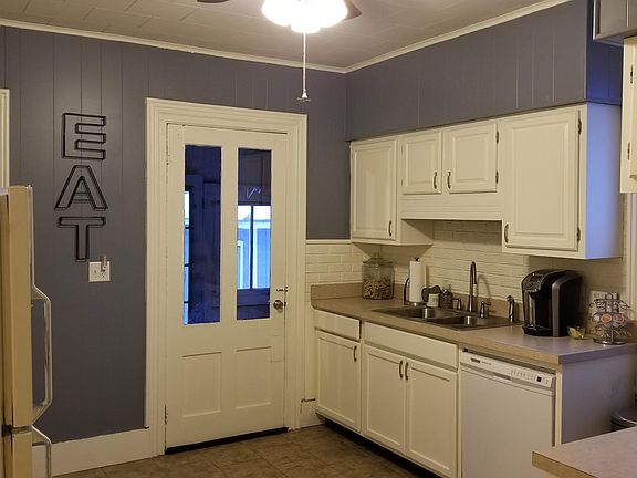Half of the kitchen shown with new kitchen sink, faucet, dishwasher