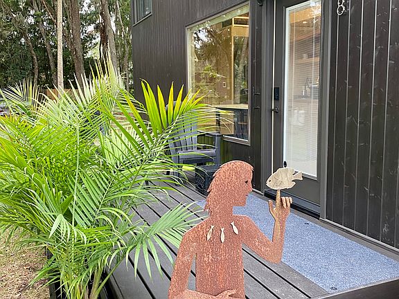 Escaperoo wooden deck and palms plus Pisces sculpture.