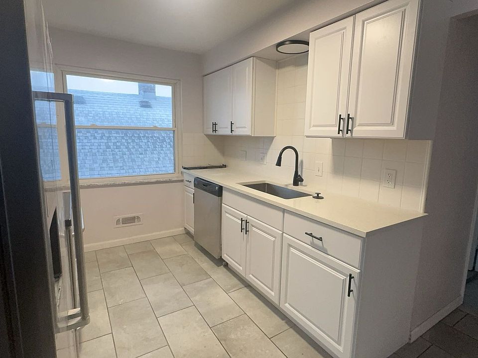 Open concept kitchen with modern quartz countertop and modern farmhouse feel and styling. Stainless Steel Fridge, Stove, Microwave & Dishwasher