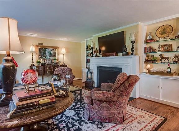Spacious living room with charming built-ins and large gas fireplace with honed granite surround and hearth