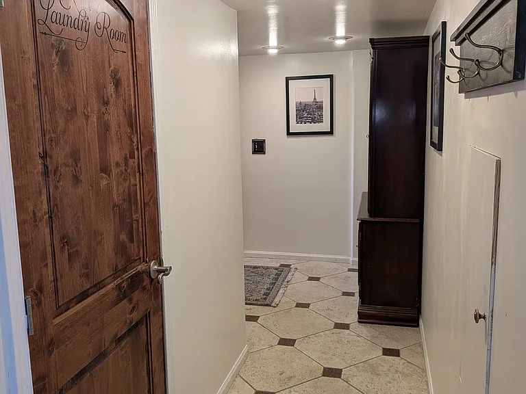 Hallway on the Garden Level, the location of a private Suite (bedroom, private bath, gas fireplace, heated bathroom tiles, closets, refrigerator and its own washer dryer. Access the laundry room, bonus rooms and 1 car garage