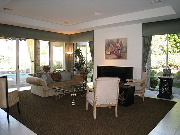 Light filled living room with high ceiling & unobtrusive wet bar. 