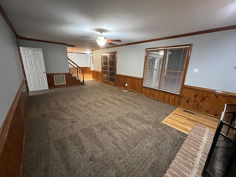 Photo from Family room looking into kitchen and stairwell straight ahead, door to entry way to the left, and double doors to the florida room.