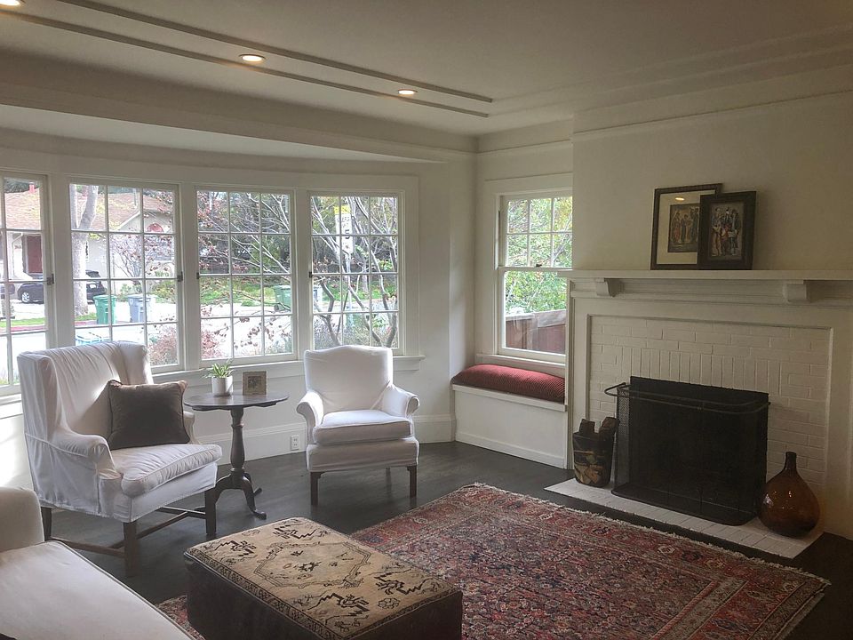 Formal living room with bay windows, window seat and wood-burning fireplace