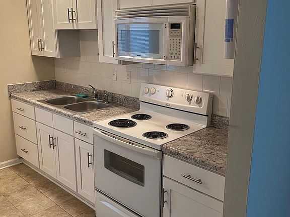 View from living room into renovated kitchen with full height cabinets.
