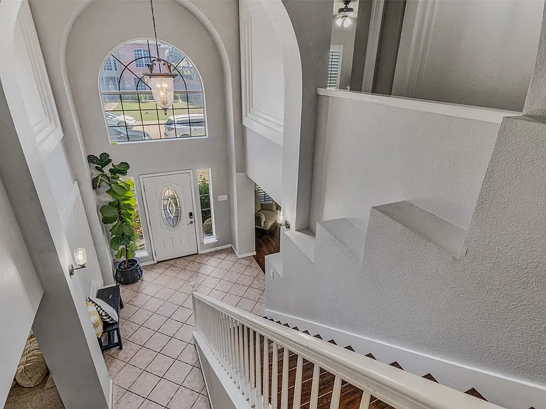Two-story entryway featuring a decorative arched window above the front door