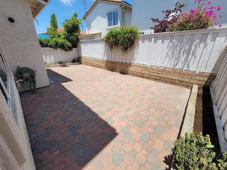 Backyard with pavers and side garden beds