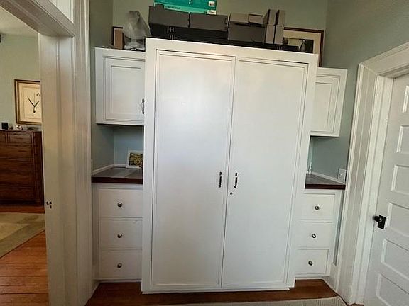 The closet room between the master bed room connects to the bathroom. There is a door between the master bed room (left) and a door leading to the bathroom (right) for privacy. The closte room has custom built-in closets, cabinets, and other cabinets (no