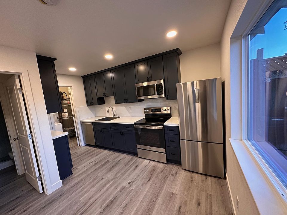 Kitchen with stove, oven, microwave, and regridgerator included. Recessed lighting. Large window provides ventilation and views into private drive-way