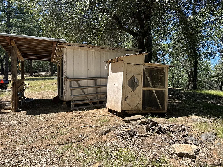 A small chicked coop is adjacent to the horse stall.