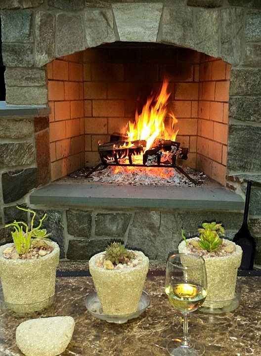 Outdoor fireplace by pool.