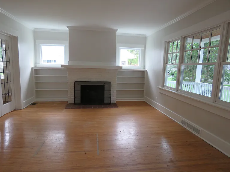 Living room with bookcases and windows... four large windows overlook the front yard.