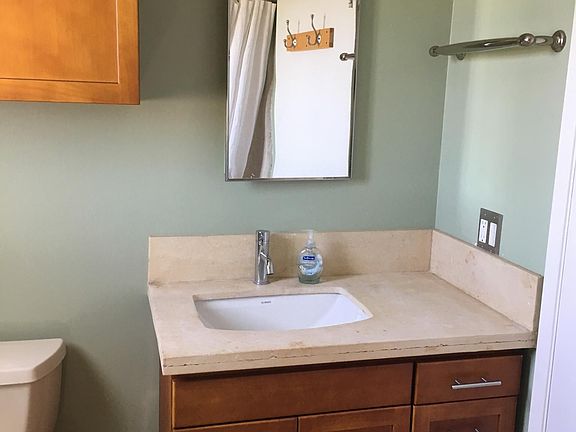 newly renovated bathroom with tub shower and limestone sink surround