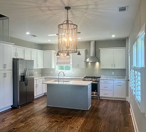 Kitchen/Dining has unique light fixtures. Gas stove w/ electric oven, dishwasher & ice maker in fridge