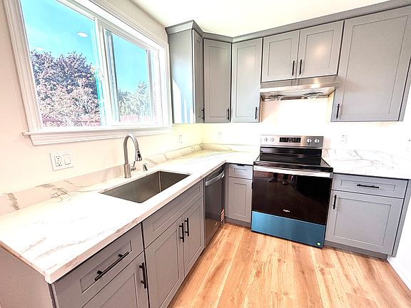 BRAND-NEW kitchen with stainless-steel appliances and flooring.