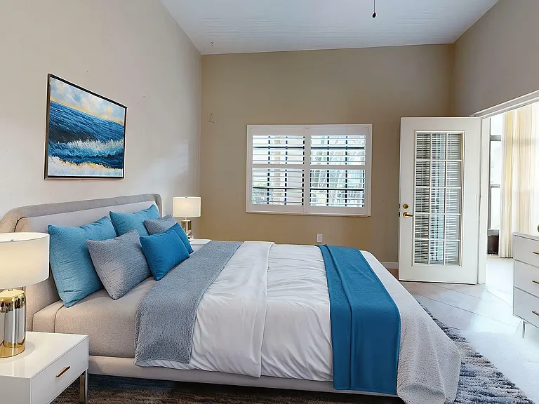 Luxurious bedroom with elegant blue accents, ample natural light, and modern furnishings.