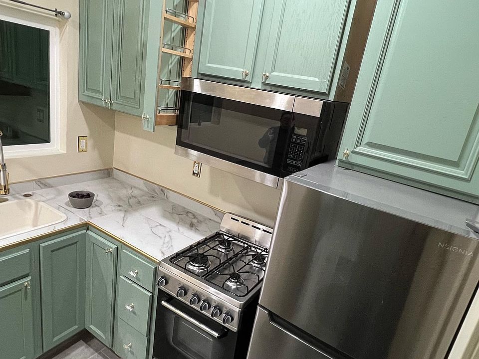 Custom kitchen with a space-saving pull-out spice rack, maximizing functionality and style in a compact layout.