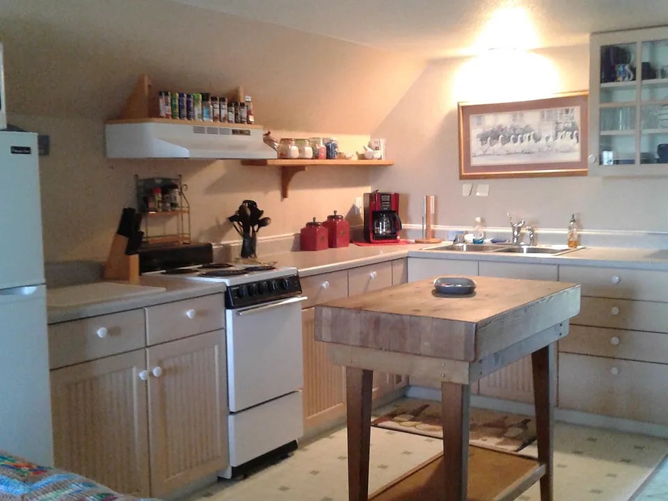 Kitchen with refrigerator, electric stove no dishwasher.
