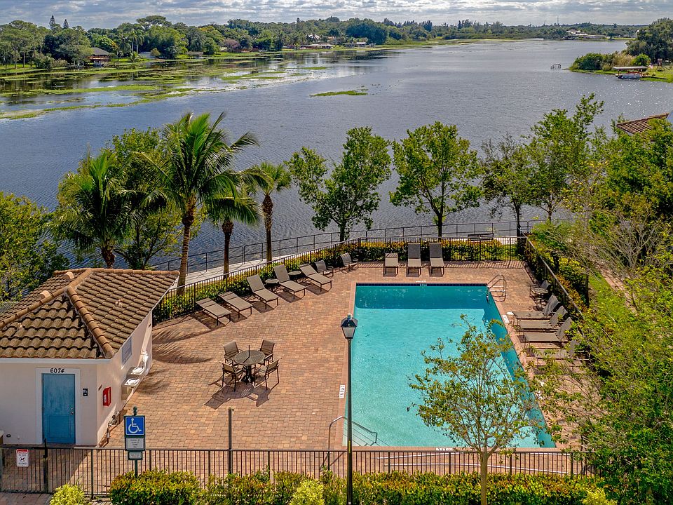 Relax by the pool with serene lake views and tropical surroundings.