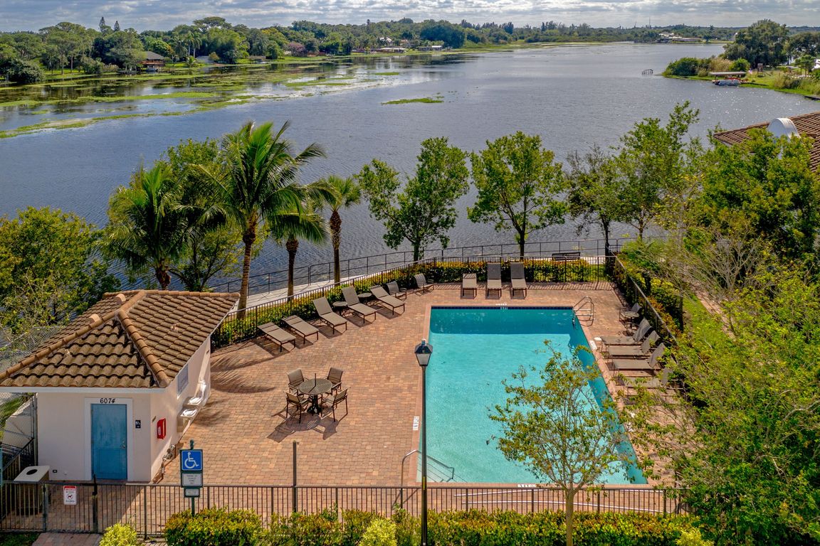 Relax by the pool with serene lake views and tropical surroundings.