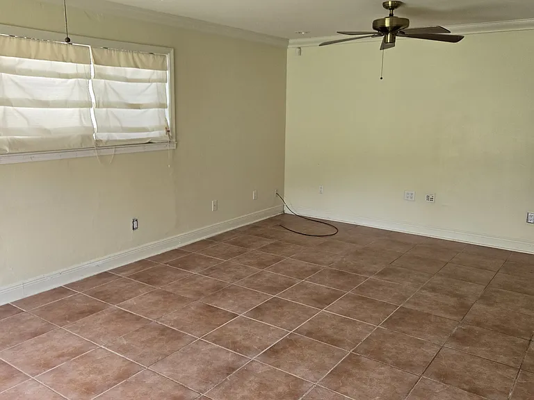 Great room/den with double ceiling fans; with connecting doors to kitchen in back; and connecting doors to foyer in front.