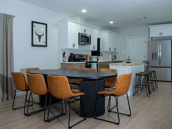 Fully equipped with stainless steel appliances, quartz countertops, a large island, and a dining table for 8