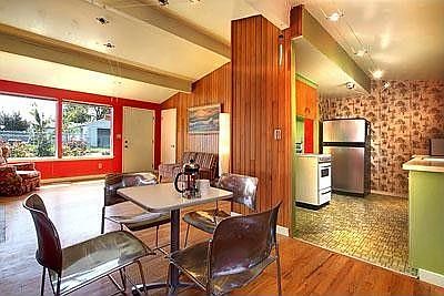 The kitchen boasts retro wallpaper, stove and linoleum with a new stainless steel refrigerator.