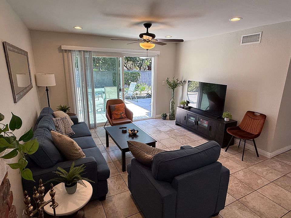 Living room viewed from fireplace with patio yard access via sliding door.