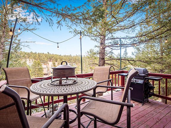 Outside patio seating with fire pit in the trees