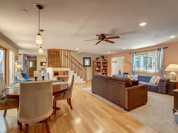 Open living area filled with natural light, warm wood floors, and flexible gathering space