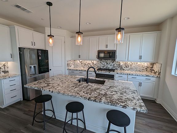 Large designer kitchen with extra-wide sink, granite countertops with island. All appliances included with rental.