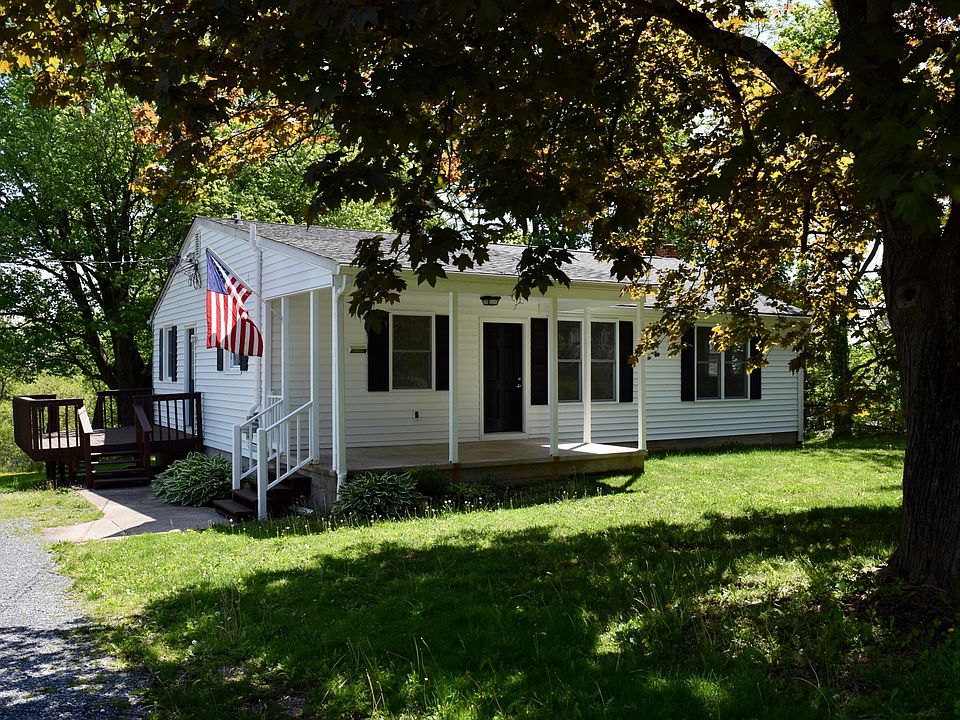 Cozy front porch and front yard with lush lawn and large shade trees