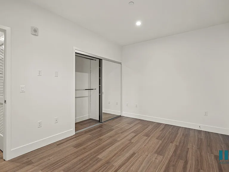 Bedroom with Mirrored Closet, Recessed Lighting, and Vinyl Flooring