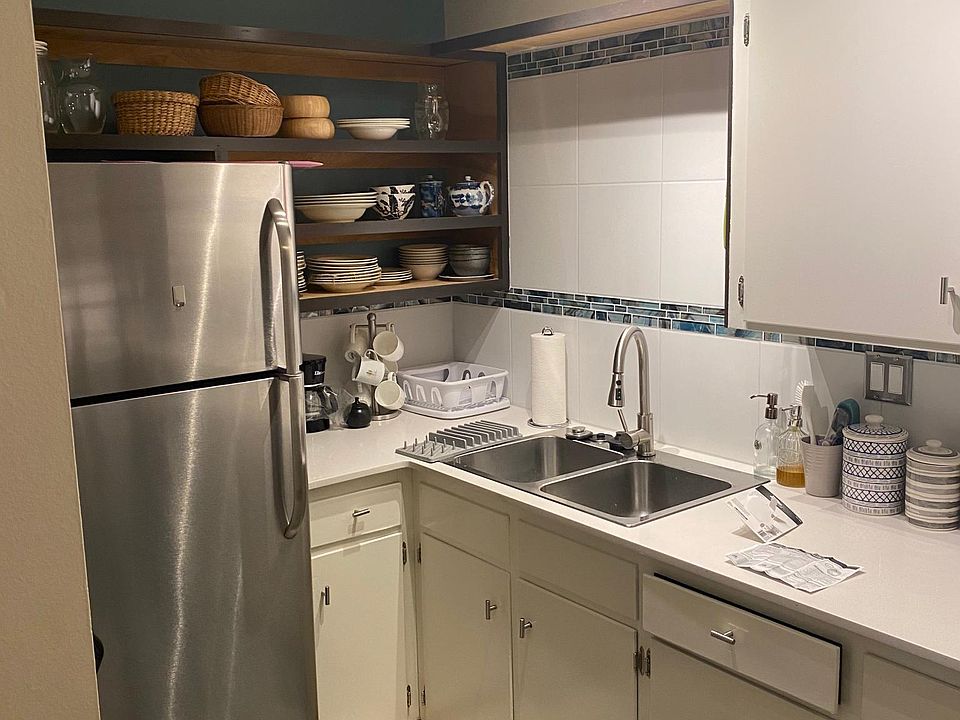 Kitchen and sink area with kitchenwares.