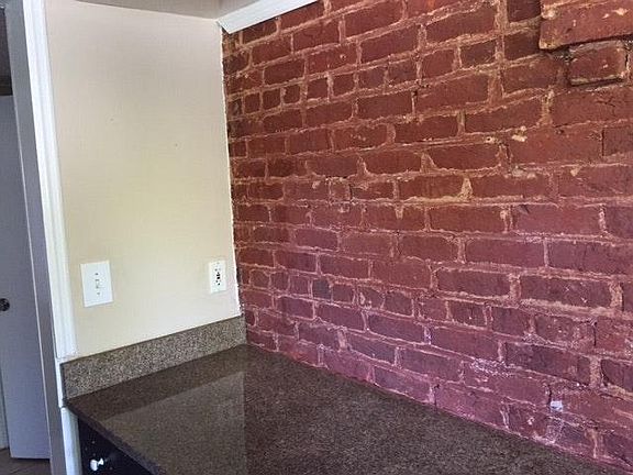 Beautiful granite in kitchen with original 100+ year old bri