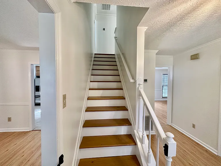 Stairs leading to the four bedrooms upstairs.