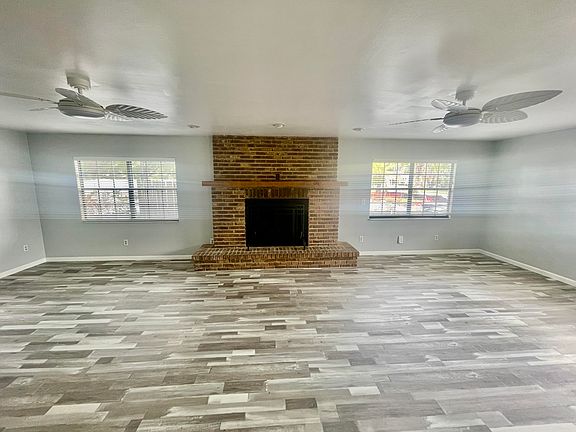 Large TV/Family Room with fireplace, ceiling fans and new flooring
