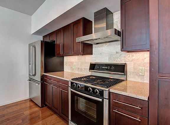 Modern kitchen with GE fridge and Bosch range and exterior venting range hood.