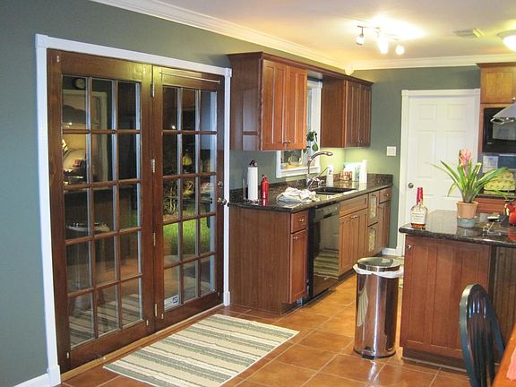 Kitchen with doors opening to spacious backyard with patio